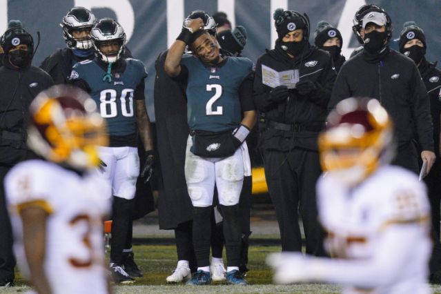 Philadelphia Eagles Jalen Hurts scratches his head on the sideline during the second half of an NFL football game against the Washington Football Team, Sunday, Jan. 3, 2021, in Philadelphia. (AP Photo/Chris Szagola)