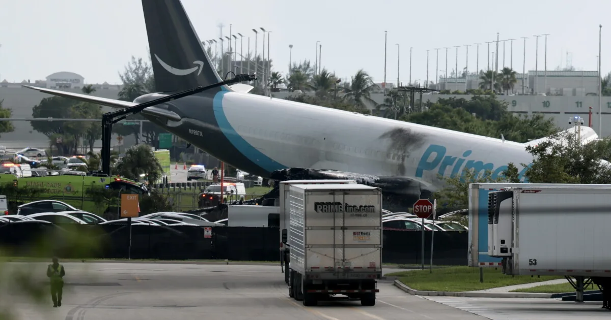 Smoke rises from a crashed Amazon cargo plane near a runway at Miami International Airport