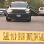 Police tape and patrol cars outside an apartment building on Willow Avenue in Kansas City