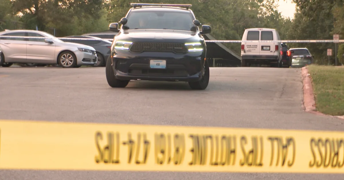 Police tape and patrol cars outside an apartment building on Willow Avenue in Kansas City